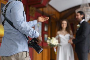 Photographer directing couple during wedding shoot.